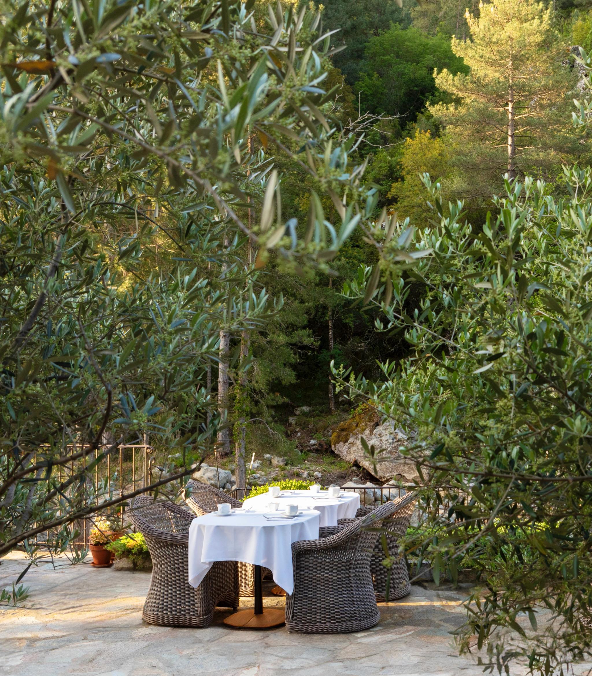 Table dressée sur une terrasse en bois au bord de la Restonica dans un hotel 4 étoiles