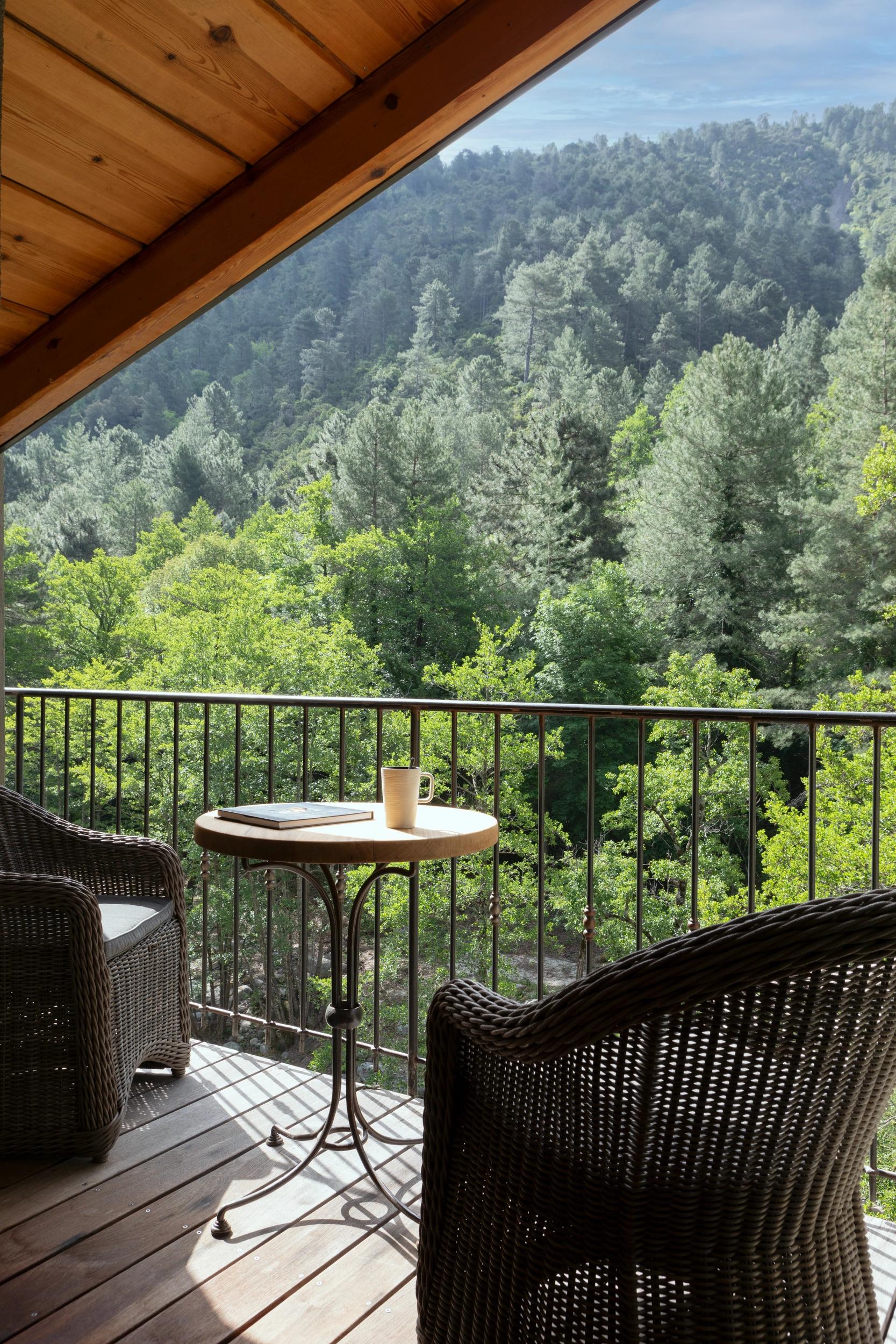 Terrasse privée de la suite A Casuccia avec mobilier en bois face à la rivière
