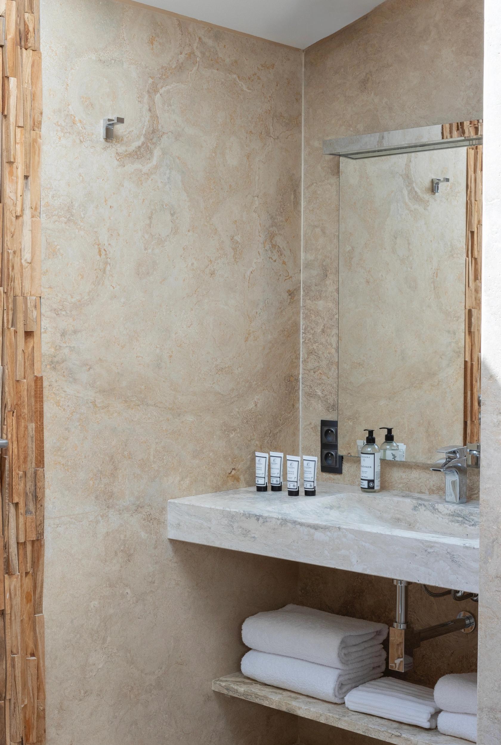 Vasque en pierre naturelle et finitions design dans la salle d’eau