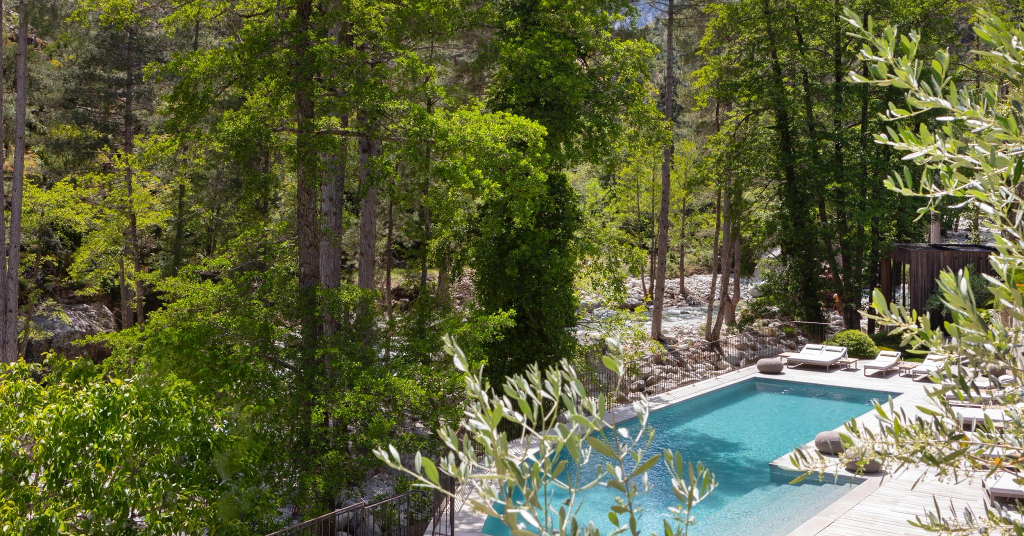 Bassin clair en pierre naturelle intégré dans la forêt de la Restonica