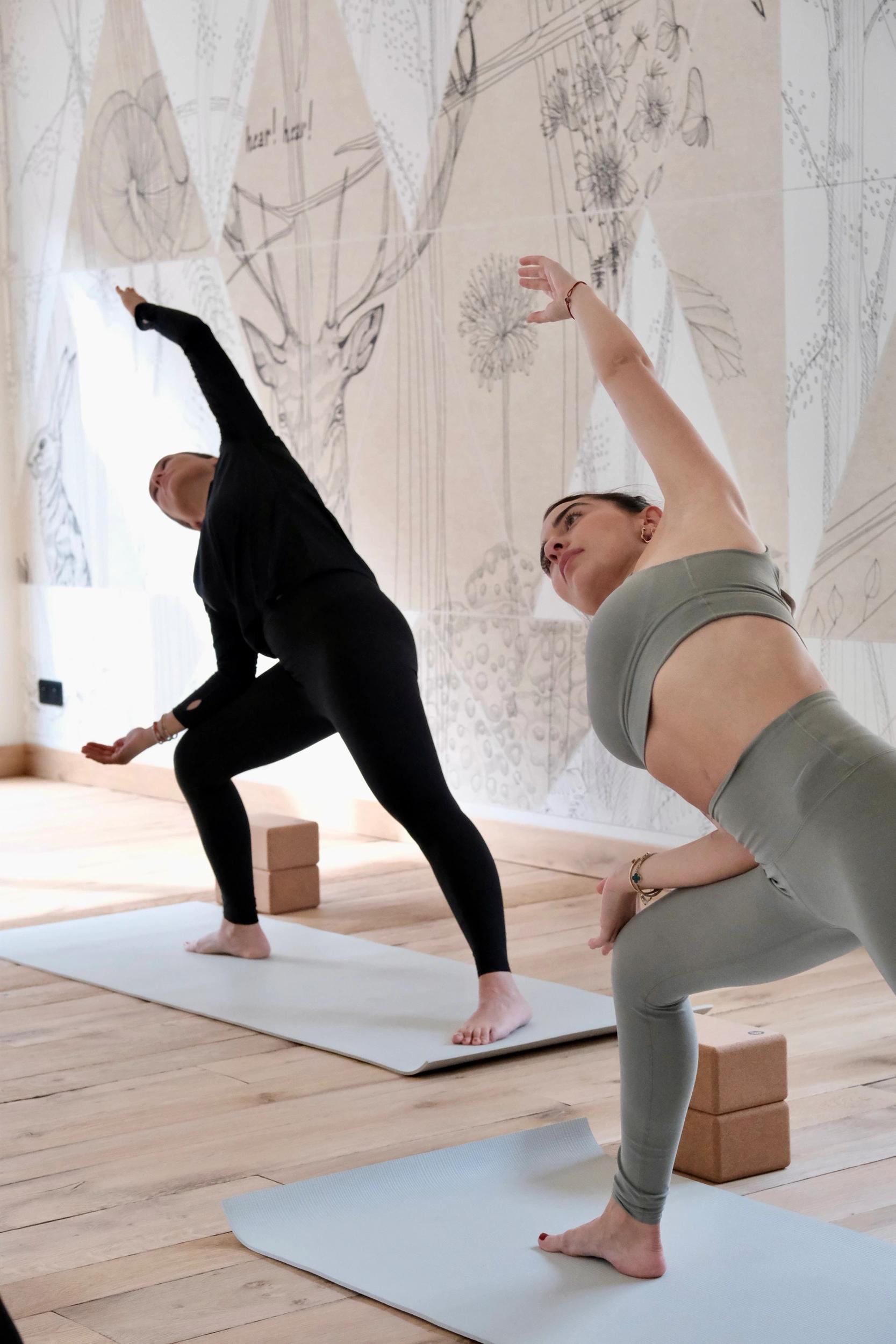 Invités pratiquant le yoga en douceur dans un espace calme et boisé