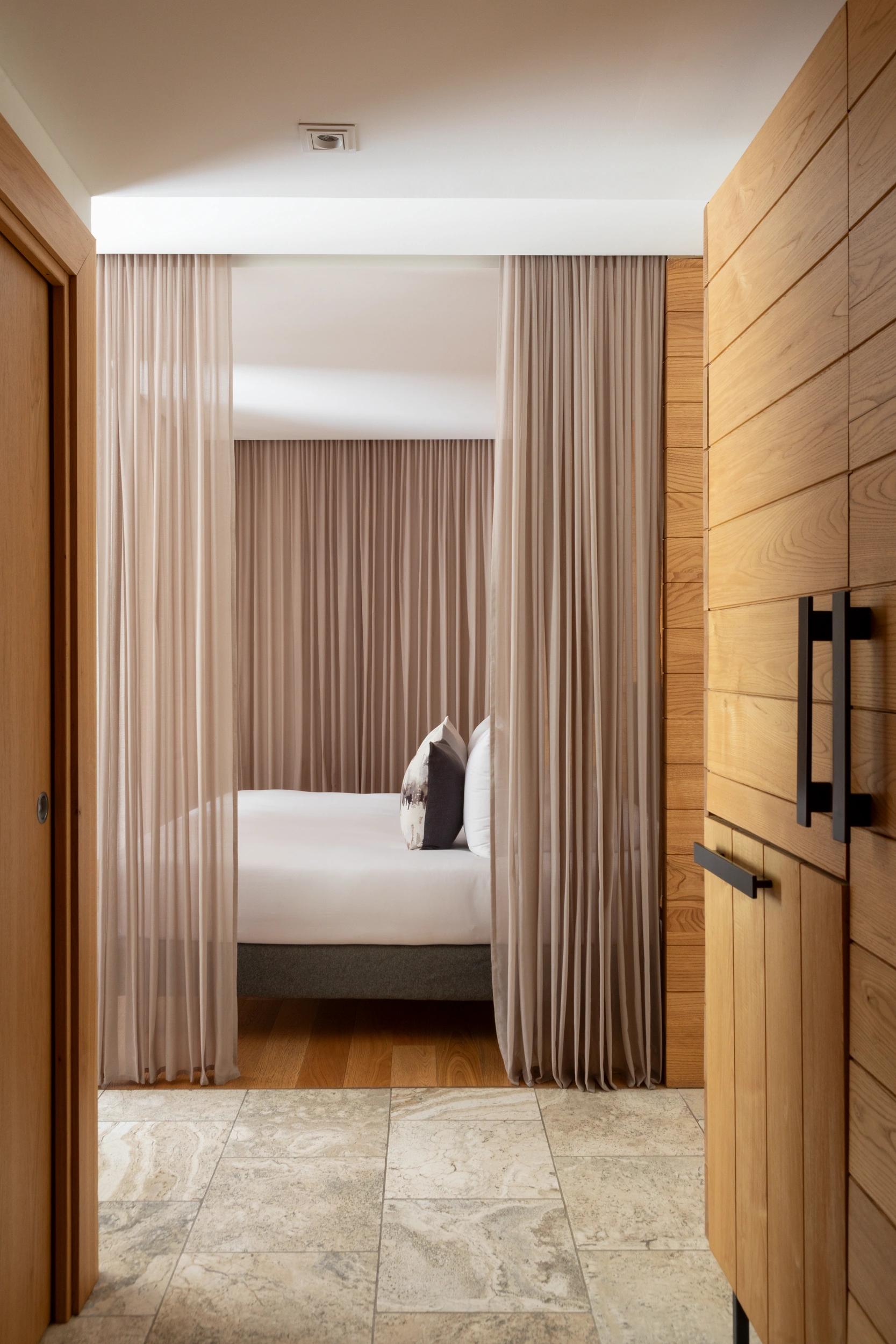 Chambre double avec lit king-size et décoration boisée à l’hôtel Dominique Colonna